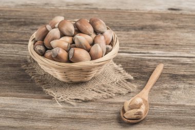 Tahta masadaki sepetin içinde çiğ fındık.