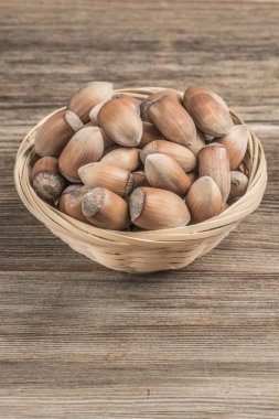 Tahta masadaki sepetin içinde çiğ fındık.