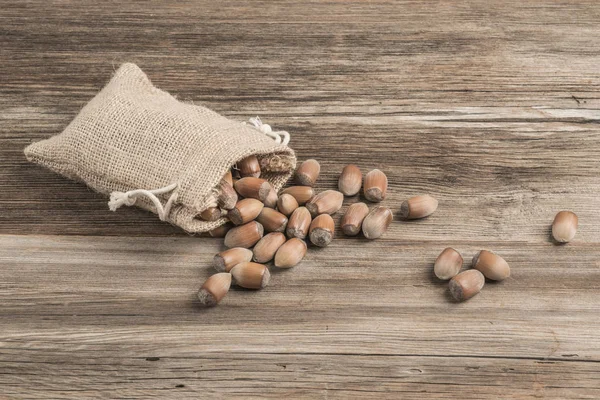 Råa hasselnötter i en säckväv på träbordet — Stockfoto