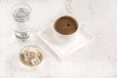 Tahta masada Türk lokumuyla servis edilen bir fincan kahve.