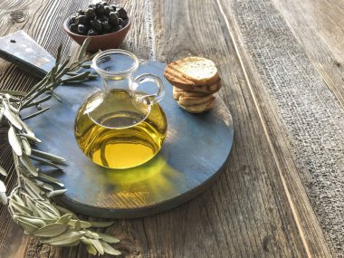 bir şişe zeytinyağı ve zeytin ahşap bir masa üzerinde