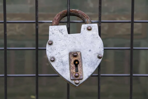 Candado colgado en una cerca de un puente para el amor — Foto de Stock