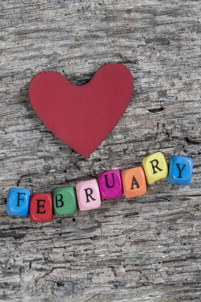 colorful cube calendar and heart on wooden background for Februa