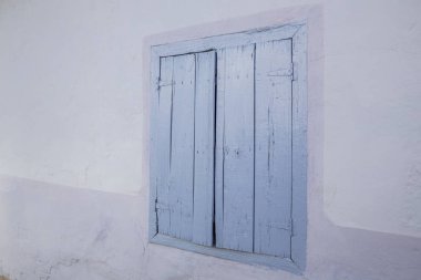 Kapalı mavi ahşap bir evin pencere perdeleri