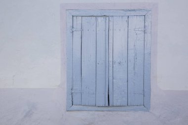 Kapalı mavi ahşap bir evin pencere perdeleri