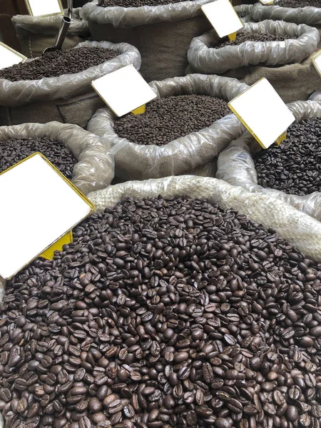 Granos de café en sacos de arpillera con etiquetas de nombre en blanco —  Fotos de Stock