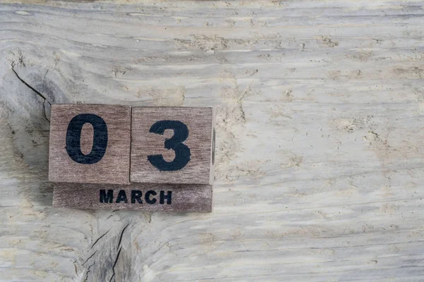 Кубический календарь для марша на деревянном фоне с копировальным пространством — стоковое фото