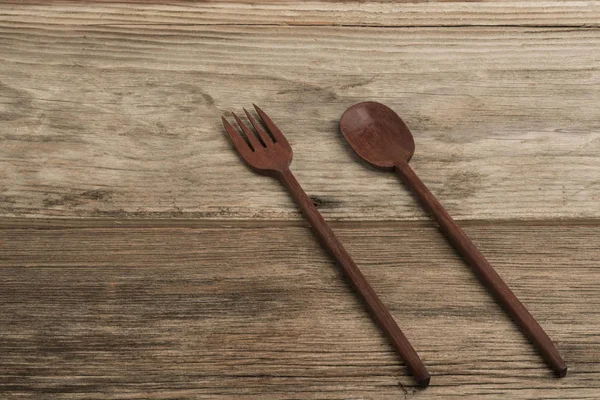 Cuchara tallada y tenedor en una mesa de madera con espacio para copiar — Foto de Stock