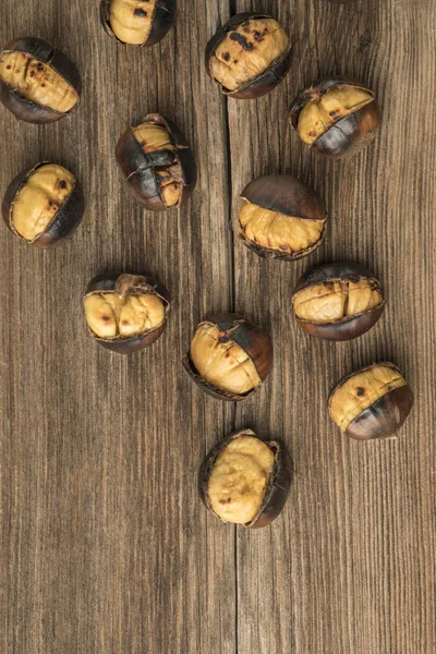 Castagne arrosto su un tavolo di legno — Foto Stock