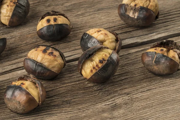 Castanhas assadas em uma mesa de madeira — Fotografia de Stock