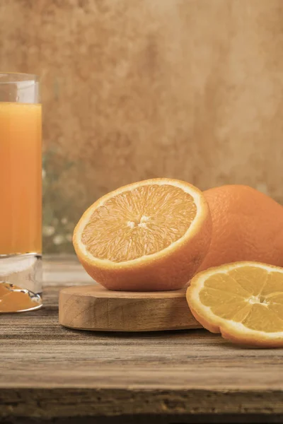 Glas frischer Orangensaft und Orangen auf Schneidebrett — Stockfoto