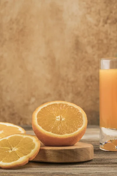 Glas frischer Orangensaft und Orangen auf Schneidebrett — Stockfoto