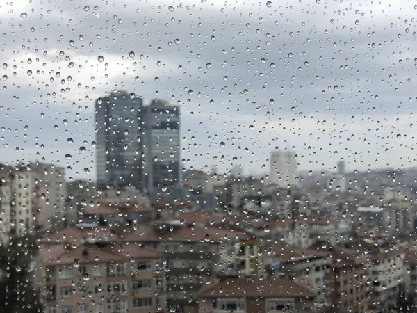 Капли дождя на оконное стекло с видом на город — стоковое фото