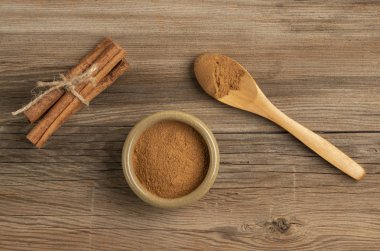 Tarçın tozu ve sopalar ahşap bir masada.