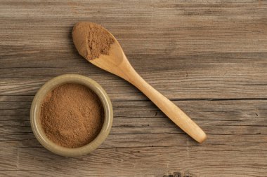 Tahta bir masanın üzerinde tarçın tozu ve kopyalama alanı