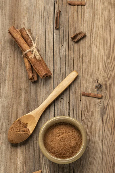 Pó de canela e paus em uma mesa de madeira com espaço de cópia — Fotografia de Stock