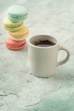 Renkli Fransız kurabiyeleri ve bir fincan kahve.