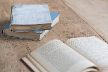 Masada bir yığın eski kitap ve açık bir tane var.