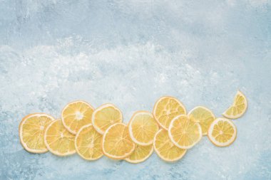 Mavi arkaplandaki kurutulmuş portakal dilimlerinin fotokopi alanının hemen üstünde.