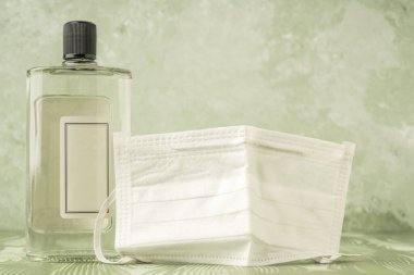 Tek kullanımlık bir sağlık maskesiyle kaplı bir şişe parfüm.