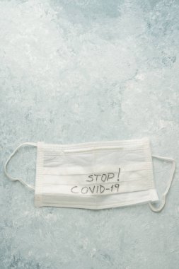 Mavi üzerinde covid-19 Corona virüsüne karşı tek kullanımlık beyaz bir sağlık maskesinin fotokopi alanı ile yakın plan görüntüsü.