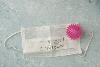 Mavi üzerinde covid-19 Corona virüsüne karşı tek kullanımlık beyaz bir sağlık maskesinin fotokopi alanı ile yakın plan görüntüsü.
