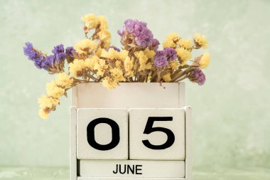 Haziran için beyaz küp takvimi kopyalama alanı ile yeşil arkaplan üzerindeki çiçeklerle dekore edilmiş