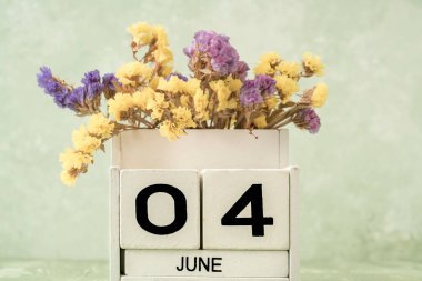 Haziran için beyaz küp takvimi kopyalama alanı ile yeşil arkaplan üzerindeki çiçeklerle dekore edilmiş