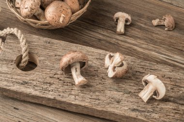 Masadaki tahta kesme tahtasının üzerinde dilimlenmiş mantarlar.