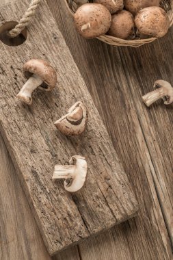 Masadaki tahta kesme tahtasının üzerinde dilimlenmiş mantarlar.