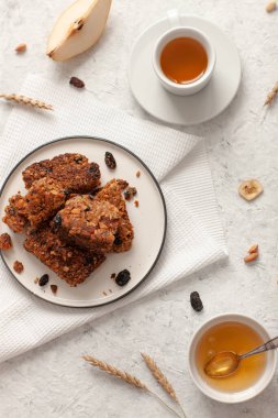 Tahıl gevreğiyle kahvaltı, beyaz ahşap arka plan manzaralı çay ve meyve..