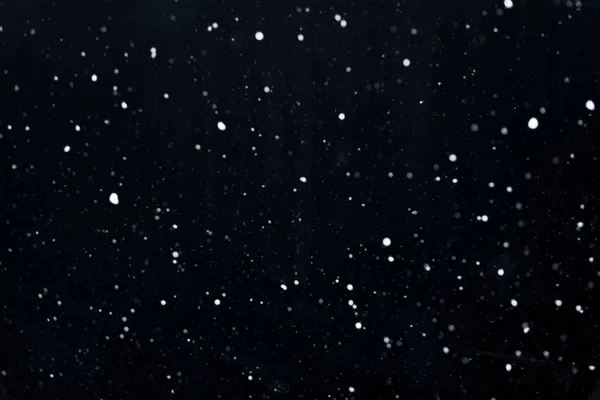 Schneeflocken am dunklen Himmel — Stockfoto