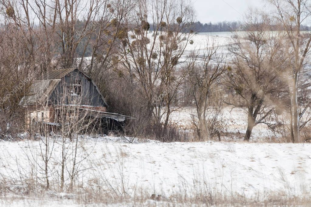 Winter landscape with abandoned house