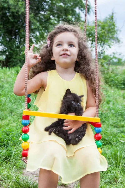 Baby girl gazdaság cica szabadban — Stock Fotó