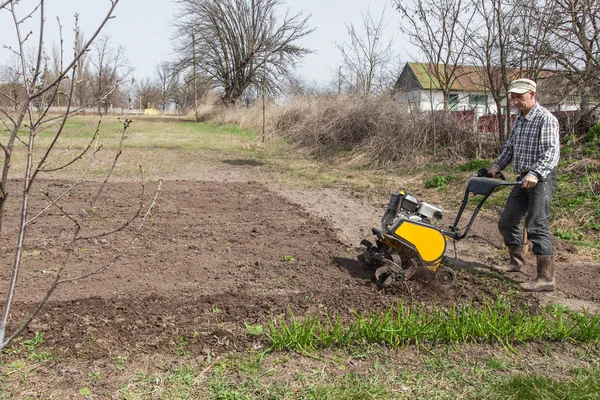 Man loosens the soil cultivator — Stock Photo, Image