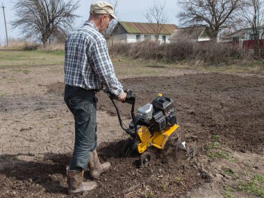 Man loosens the soil cultivator clipart