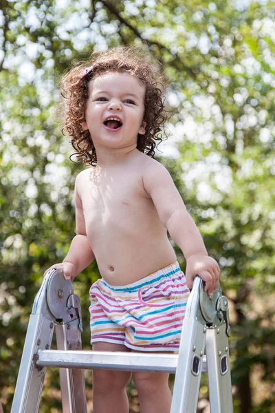 Sorrindo bebê menina escalando escada rolante — Fotografia de Stock