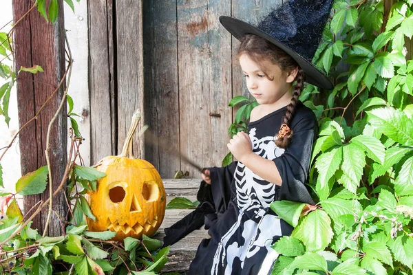 Kleine Hexe mit Halloween-Kürbis — Stockfoto