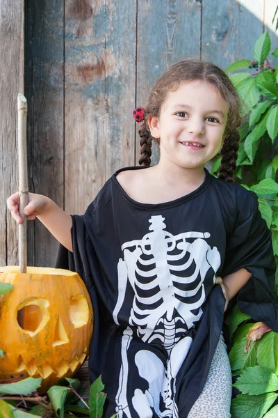 Kleine Hexe mit Halloween-Kürbis — Stockfoto