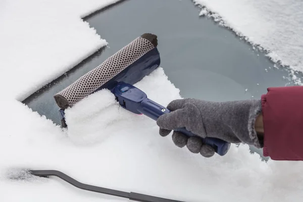 Rengöra vindrutan från snö med skrapa — Stockfoto