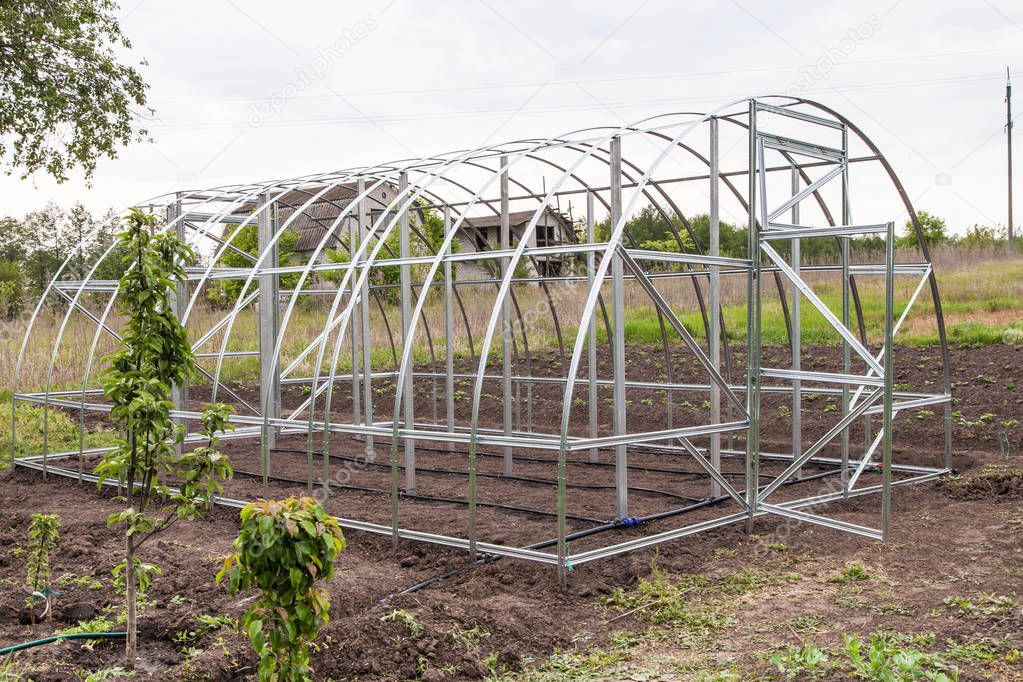 Frame of greenhouse is installed in garden