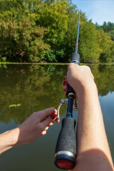 Mão feminina detém a pesca girando ao ar livre — Fotografia de Stock