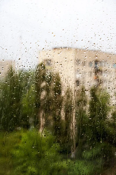 Chuva de verão no fundo embaçado da cidade — Fotografia de Stock