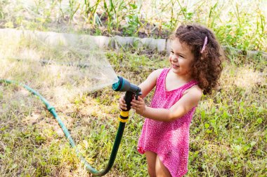 Bir su püskürtücü ile oynayan kız