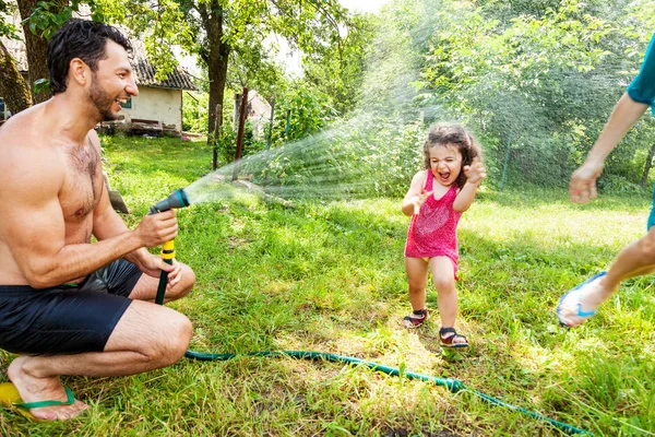 Föräldrar spelar med lilla dotter utomhus — Stockfoto