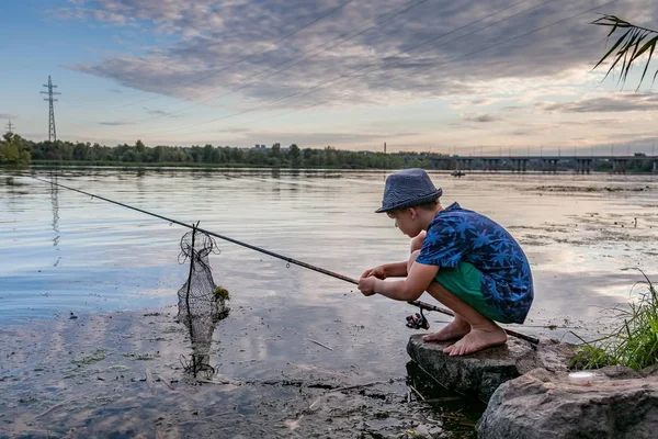 釣竿を持った少年が魚を捕まえる — ストック写真