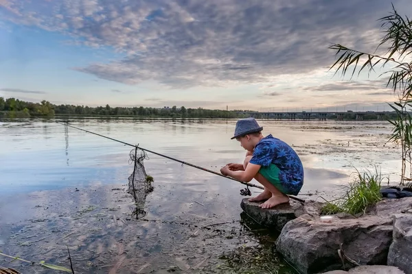 Αγόρι με καλάμι ψαρέματος πιάνει ψάρι — Φωτογραφία Αρχείου