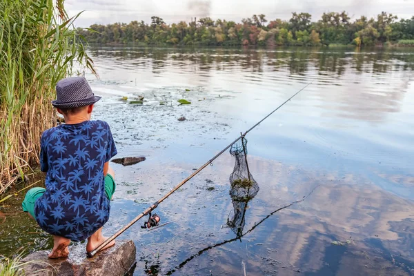 釣竿を持った少年が魚を捕まえる — ストック写真