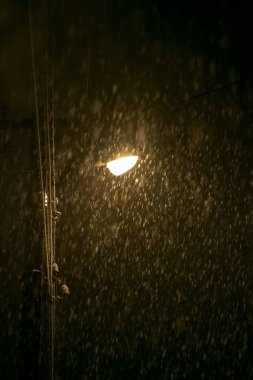 Fenerin ışığı kar fırtınası ve kar fırtınasını aydınlatır.