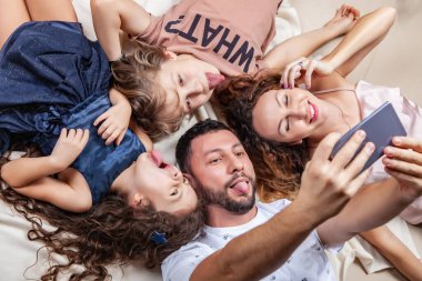 Mutlu aile akıllı telefonuyla selfie çekiyor.